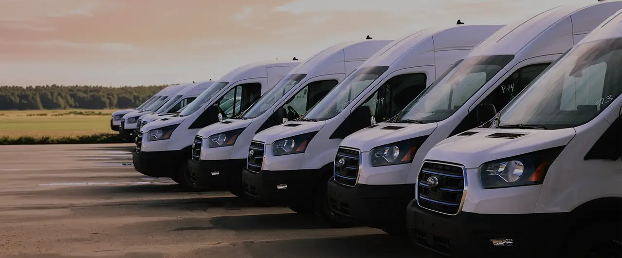 a row of fleet vans in white during a sunset