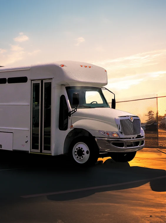 White shuttle bus parked next to a security fence at a prison near Jackson